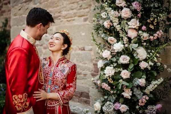 bride and groom in traditional Chinese wedding outfits outside Hampton Court Castle venue