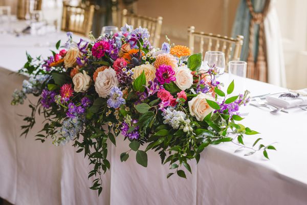 brightly coloured wedding floral display at Hampton Court Castle reception